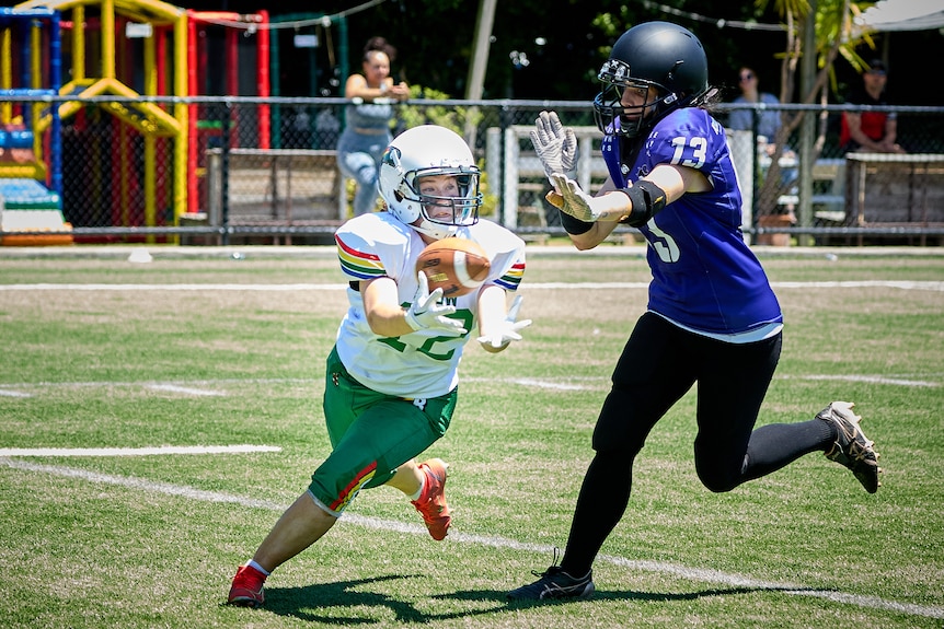 A UNSW Raiders player running with the ball.