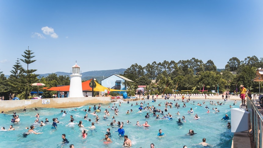 People swimming in a pool at a water park.