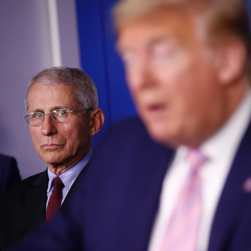 Director of the National Institute of Allergy and Infectious Diseases Dr. Anthony Fauci listens as President Donald Trump speaks