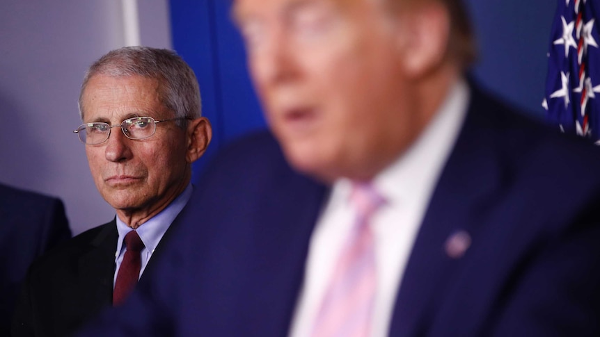 Director of the National Institute of Allergy and Infectious Diseases Dr. Anthony Fauci listens as President Donald Trump speaks