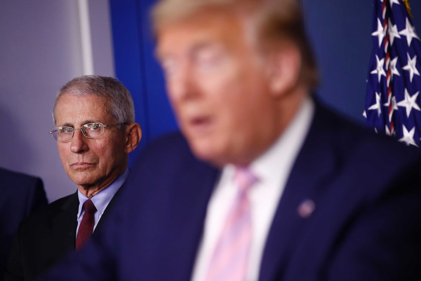 Director of the National Institute of Allergy and Infectious Diseases Dr. Anthony Fauci listens as President Donald Trump speaks