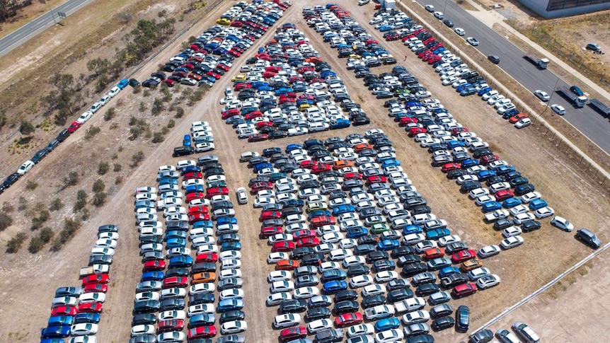 Aerial shot of hundreds of cars in a car yard with hail damage