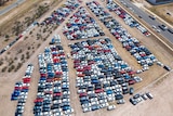 Aerial shot of hundreds of cars in a car yard with hail damage