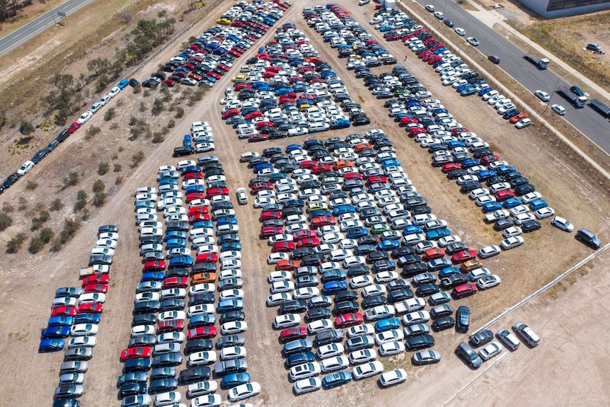 Aerial shot of hundreds of cars in a car yard with hail damage