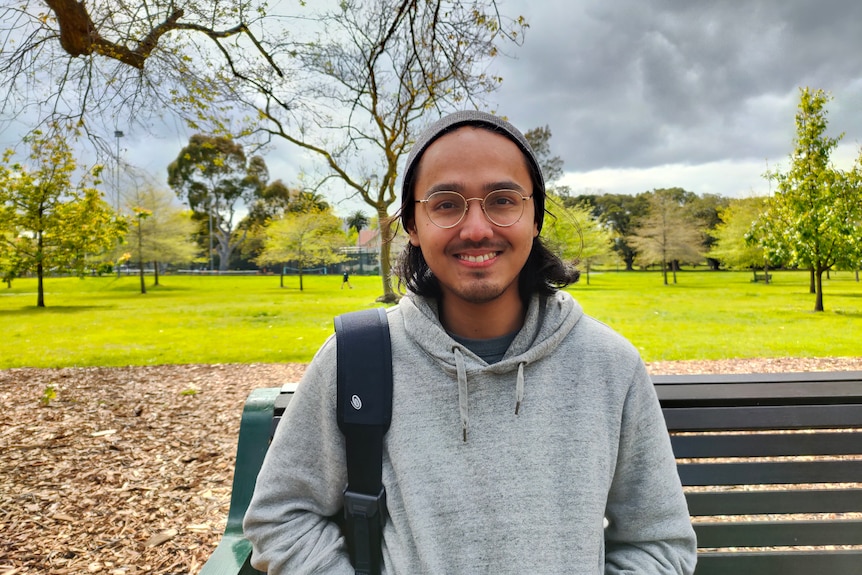 Giovanni van Empel smiles for a photo while standing in a green park.