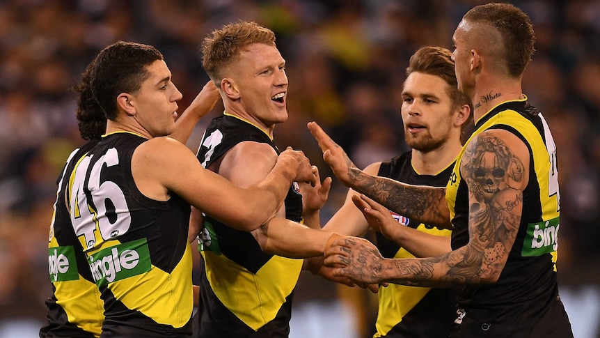 Josh Caddy of the Tigers (3L) reacts after kicking a goal against Geelong at the MCG.