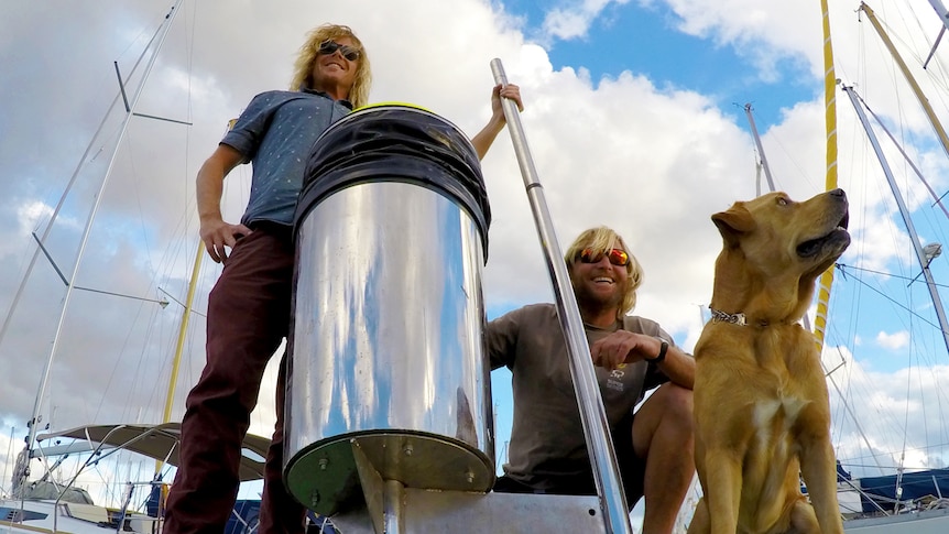 Seabin founders Pete Ceglinski and Andrew Turton pictured with a sea bin and a dog.