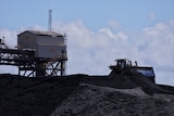 A truck on top of a pile of coal