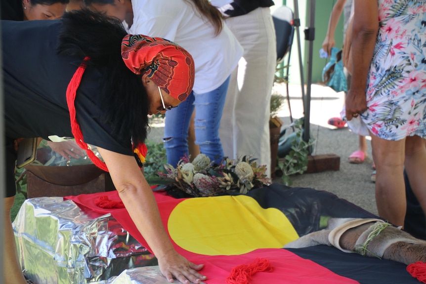 A woman placing an Aboriginal flag on two boxes.