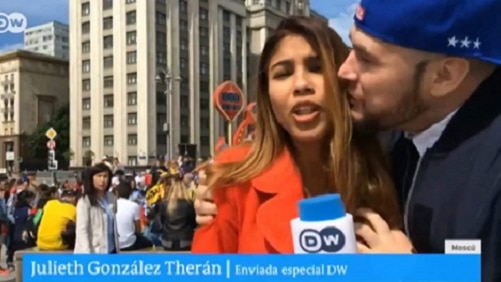 A female reporter being groped by a male football fan during a TV live cross during the FIFA World Cup.