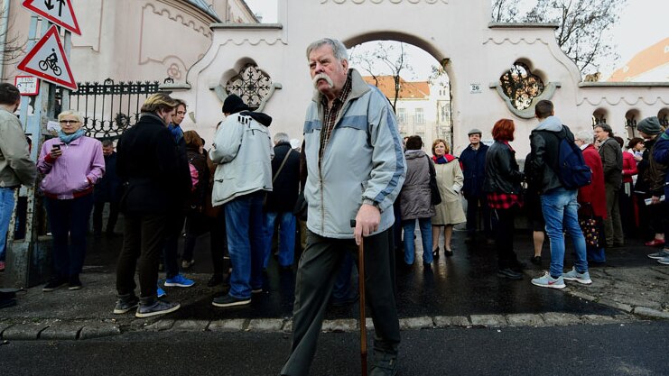 A man passes by teachers and their sympathisers outside a Budapest high school.