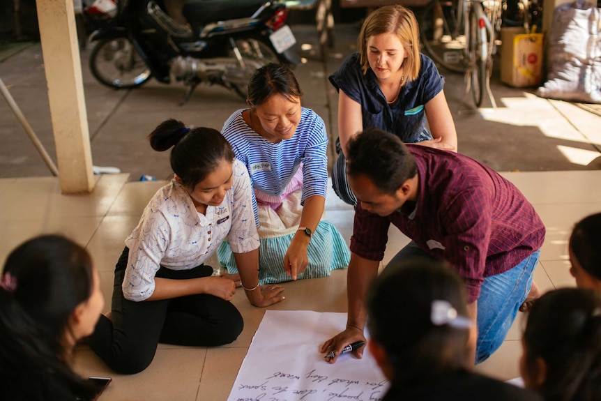 Christine Deng (centre) working in Cambodia for Oaktree.