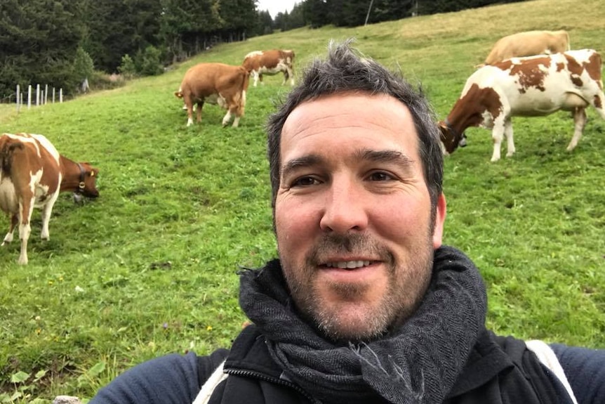 Councillor Jeremy Rich captures a photo of himself with cattle grazing in the background.