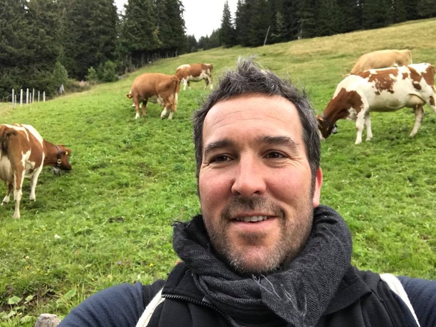 Councillor Jeremy Rich captures a photo of himself with cattle grazing in the background.