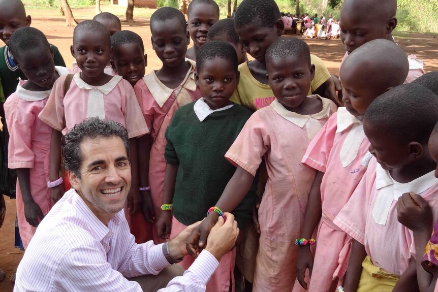 White man with African school girls