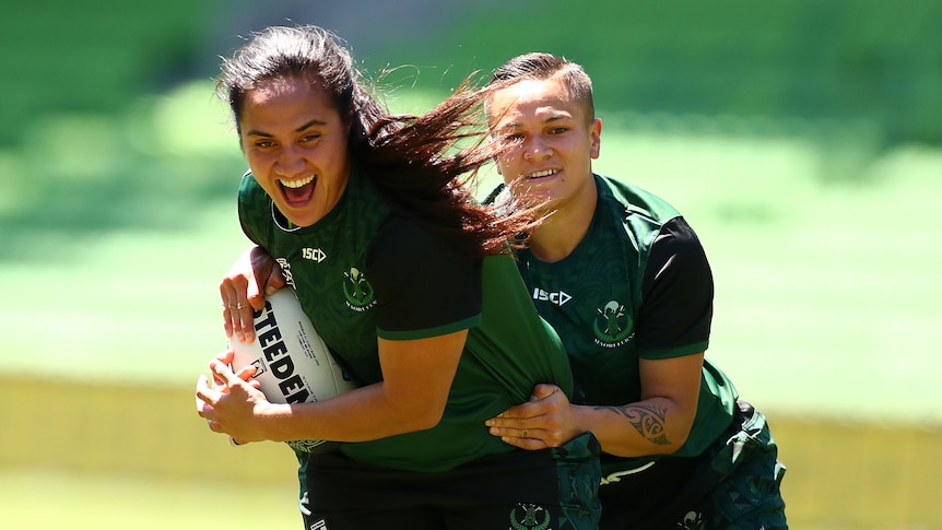 Tazmin Gray smiles as she's tackled by Christyl Stowers.
