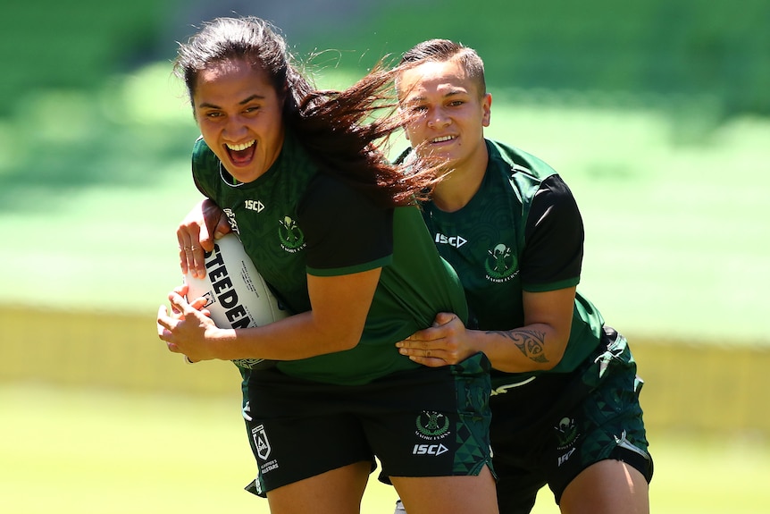 Tazmin Gray smiles as she's tackled by Christyl Stowers.