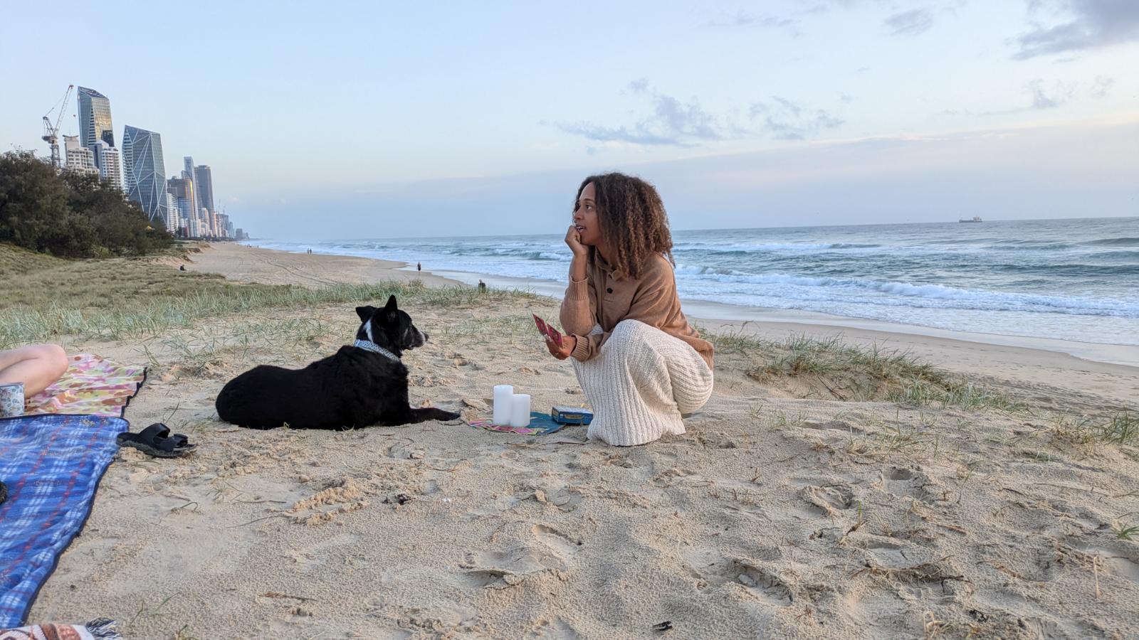 Tiana Storm y su perro se sientan en la arena de Broadbeach en Gold Coast.