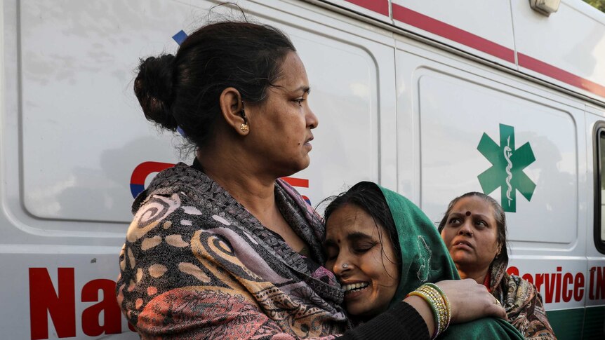 A woman cries while being comforted by another woman.