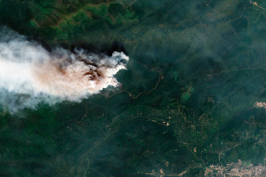 A satellite image showing a fire at Shovel Creek, near Fairbanks, Alaska. It is a huge plume of smoke surrounded by green.