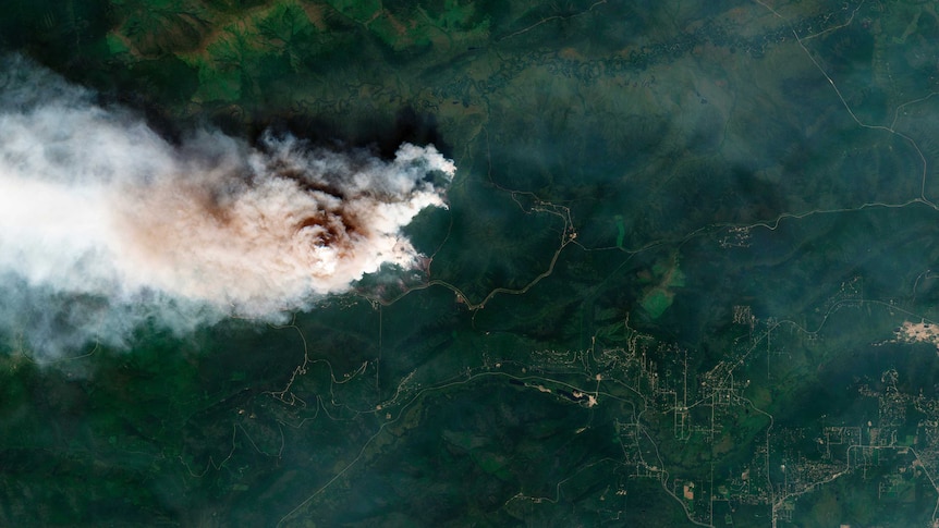 A satellite image showing a fire at Shovel Creek, near Fairbanks, Alaska. It is a huge plume of smoke surrounded by green.