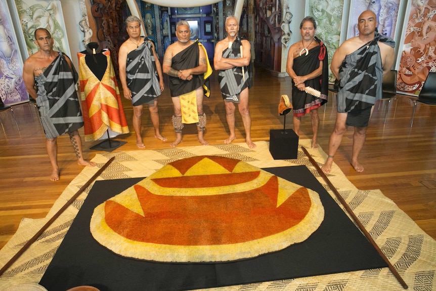 Kia'i or guardians stand next to Indigenous Hawaiian garments