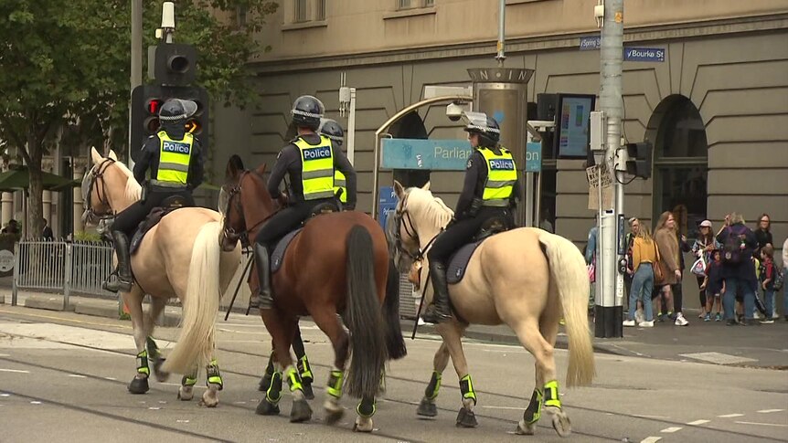 Three police officers on horseback on Spring Street in central Melbourne