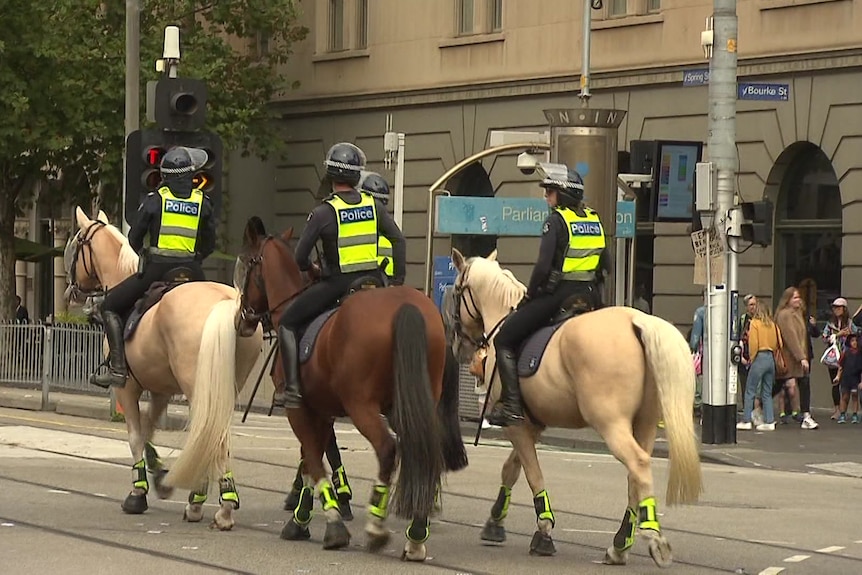 Three police officers on horseback on Spring Street in central Melbourne
