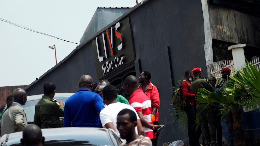 Police officers and officials stand outside the Livs Night Club.