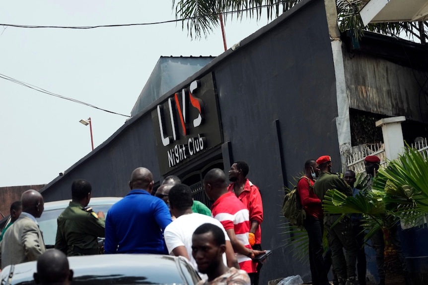 Police officers and officials stand outside the Livs Night Club.