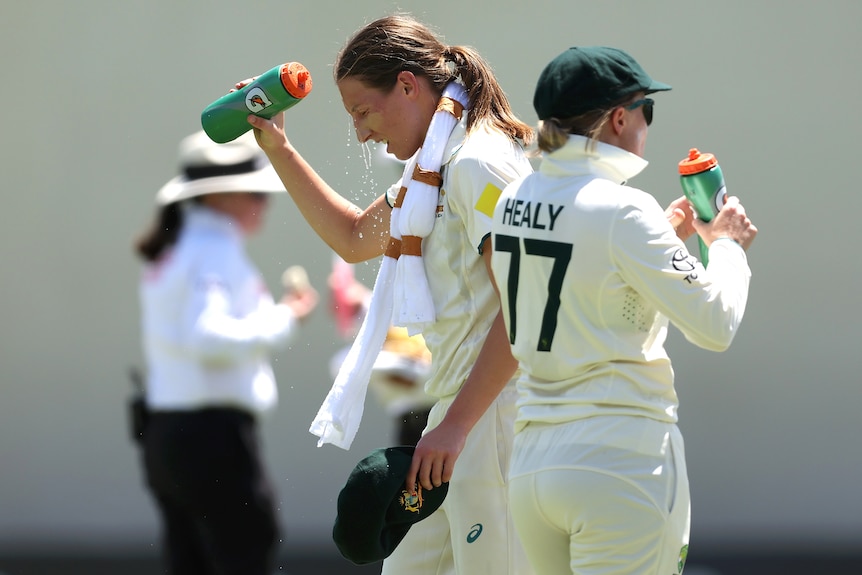 澳大利亚保龄球手达西·布朗在测试期间将水倒在头上，而艾莉莎·希利则在她旁边喝酒。