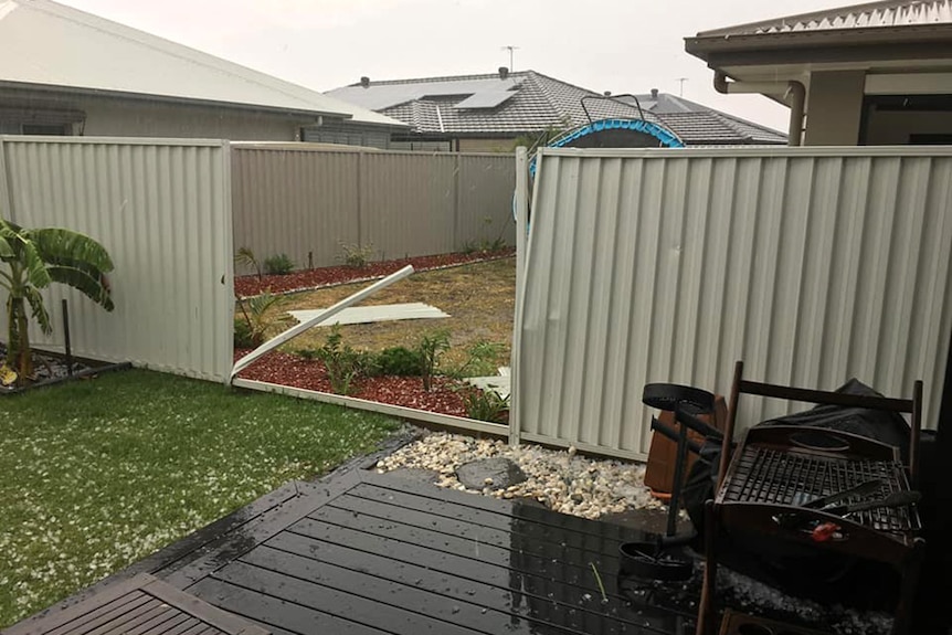 A fence with a panel missing after a storm