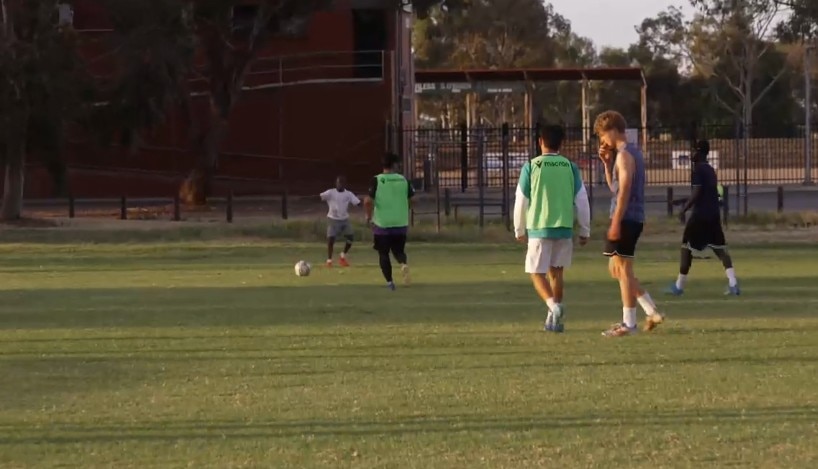 Teenage soccer players on a field at twilight