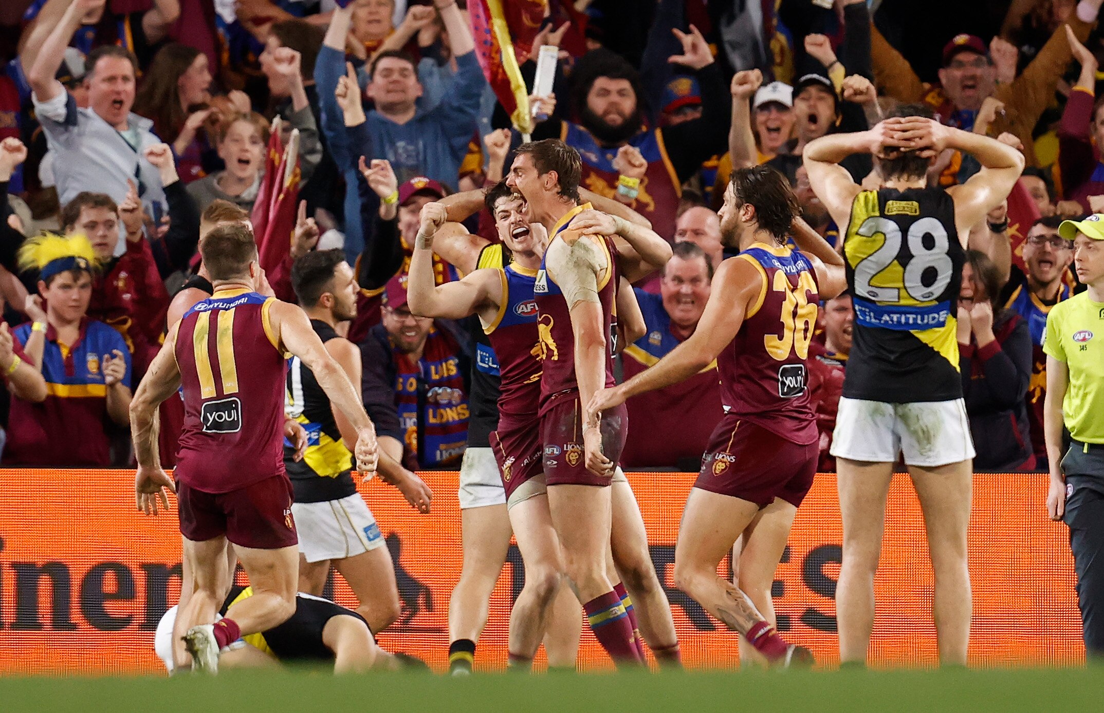 Lions players surround Joe Daniher as the crowd goes wild