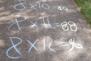 Number eight times tables written in chalk down a footpath