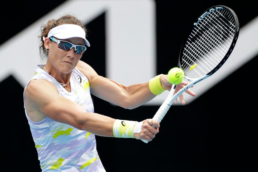 An Australian female tennis player hits a single-handed backhand at the Australian Open.