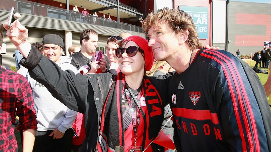 Hird takes photo with fan at Essendon training