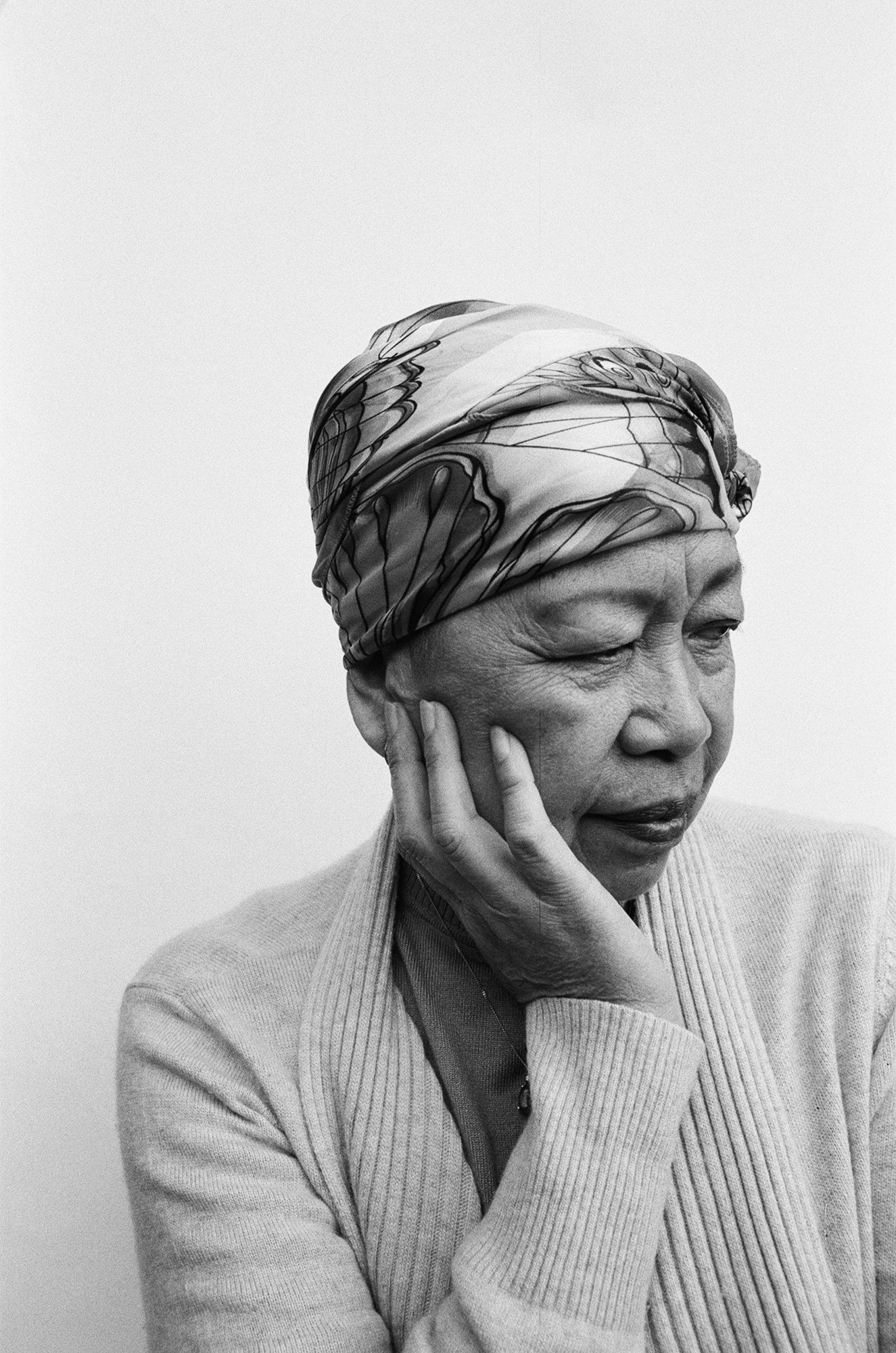 A black and white photo shows a close-up of an Asian woman looking to the side of camera.