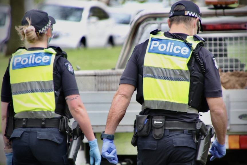 The backs of two uniformed police officers in Melbourne.