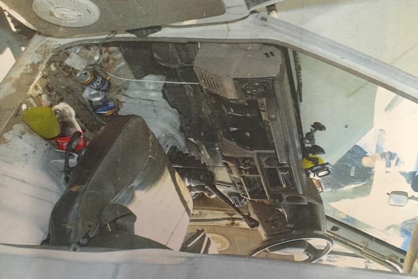 Mud and cans of alcohol inside an old car.