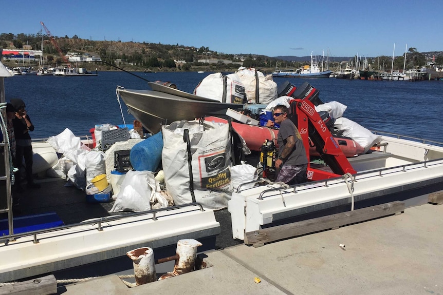 One of the boats returning from the clean-up is packed with rubbish.