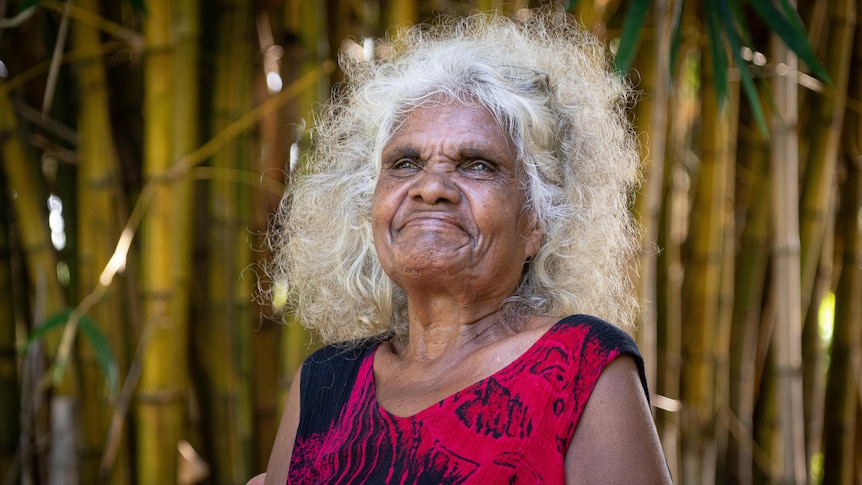 Helen Fejo-Frith smiles and sits outside in the Bagot community.
