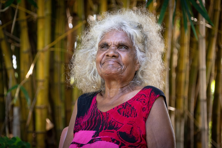 Helen Fejo-Frith smiles and sits outside in the Bagot community.