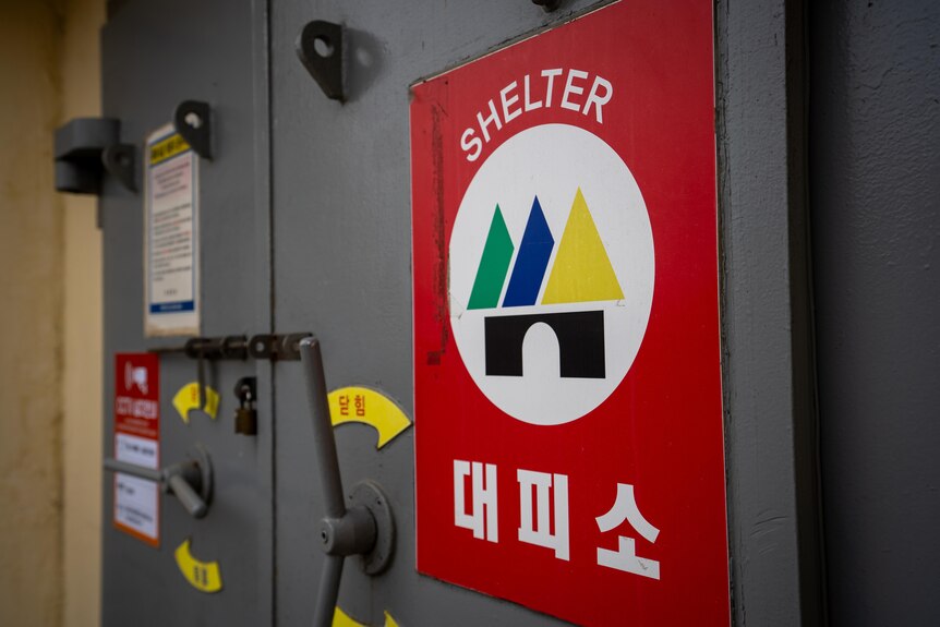 A close up of a bunker with a sign displaying the word Shelter.