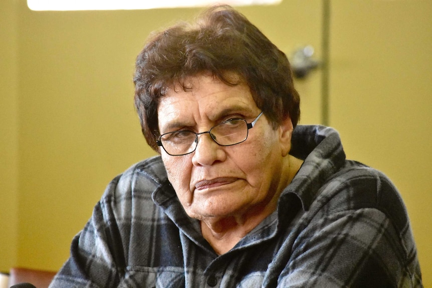An Aboriginal woman wears glasses and has brown hair.