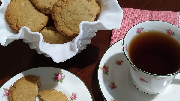 A plate of biscuits and cup of tea side by side