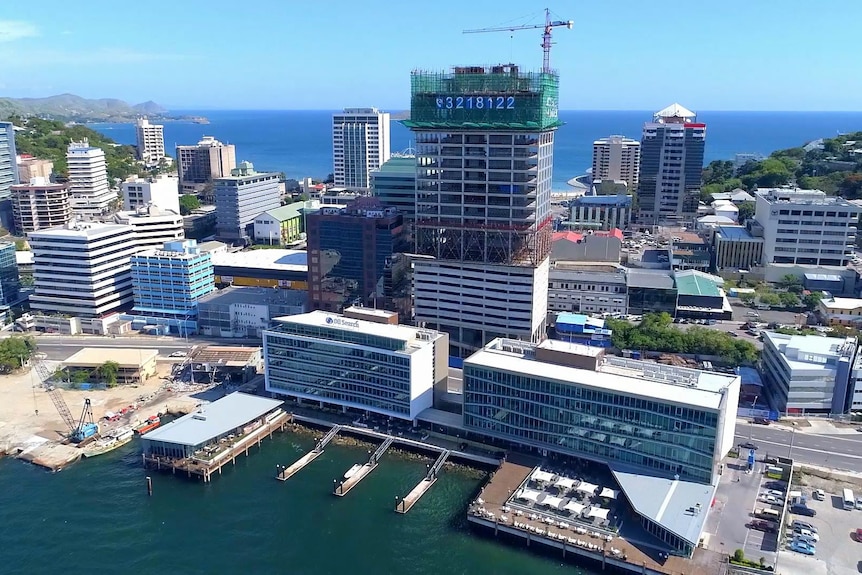 A half-completed building covered in scaffolding on Port Moresby's shoreline