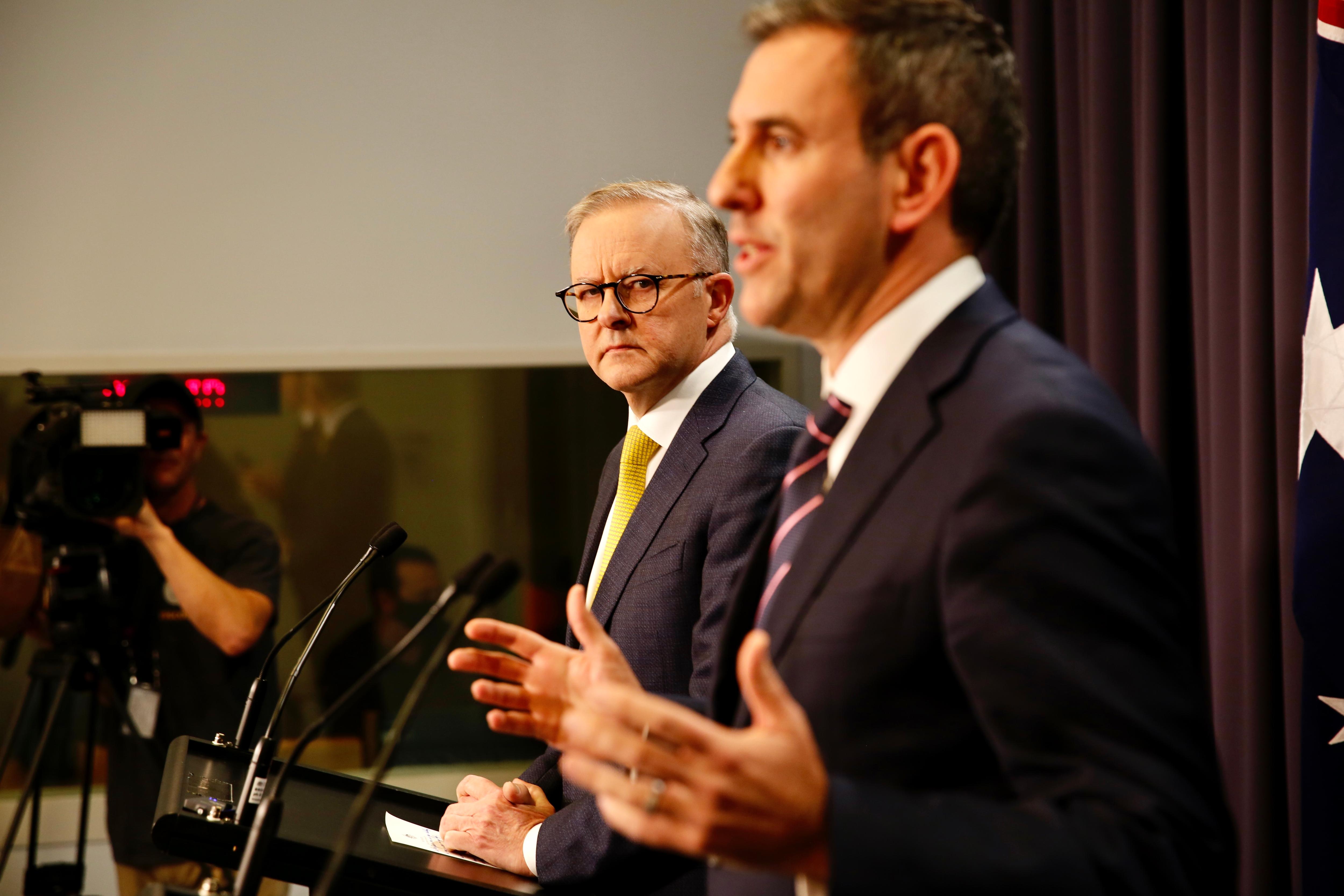 Anthony Albanese looks to the side towards Jim Chalmers. 