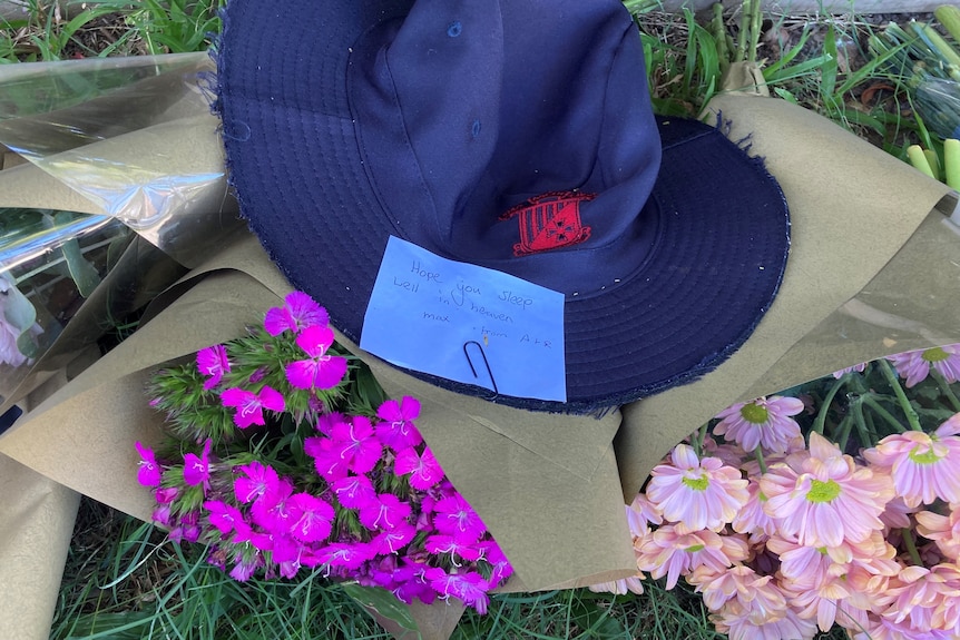 A school hat, flowers and a note.