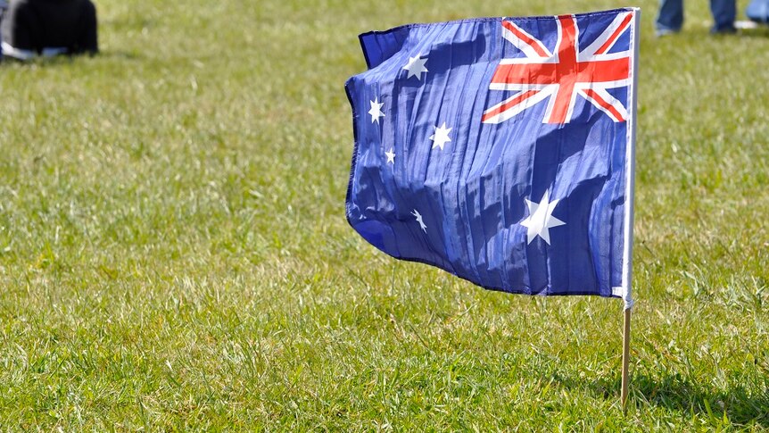 Australian flag planted in the grass.